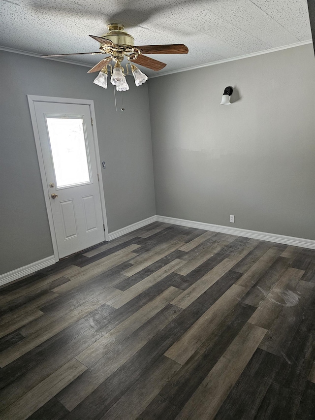 empty room featuring ceiling fan, dark hardwood / wood-style flooring, crown molding, and a textured ceiling