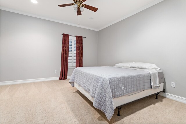 carpeted bedroom featuring ceiling fan and crown molding