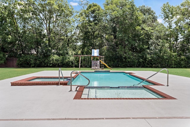 view of pool with an in ground hot tub, a yard, a playground, and a patio