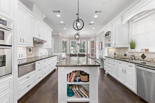 kitchen with white cabinetry, a center island, dark stone counters, and appliances with stainless steel finishes