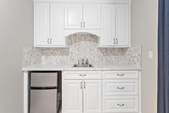 kitchen featuring stainless steel refrigerator and white cabinets