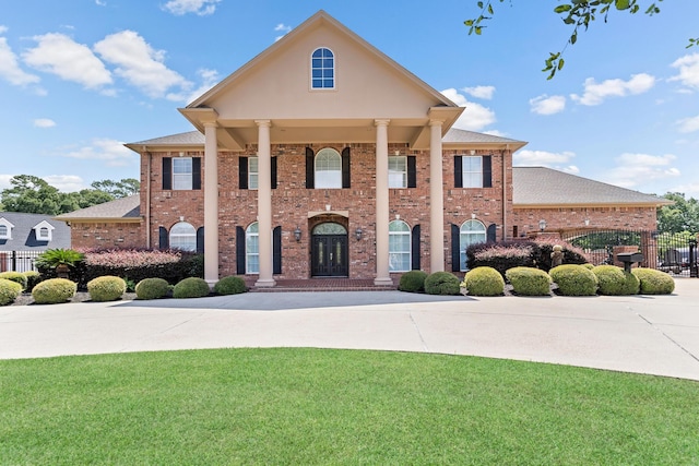 greek revival house featuring a front yard