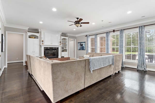 living room with ceiling fan, ornamental molding, and dark wood-type flooring