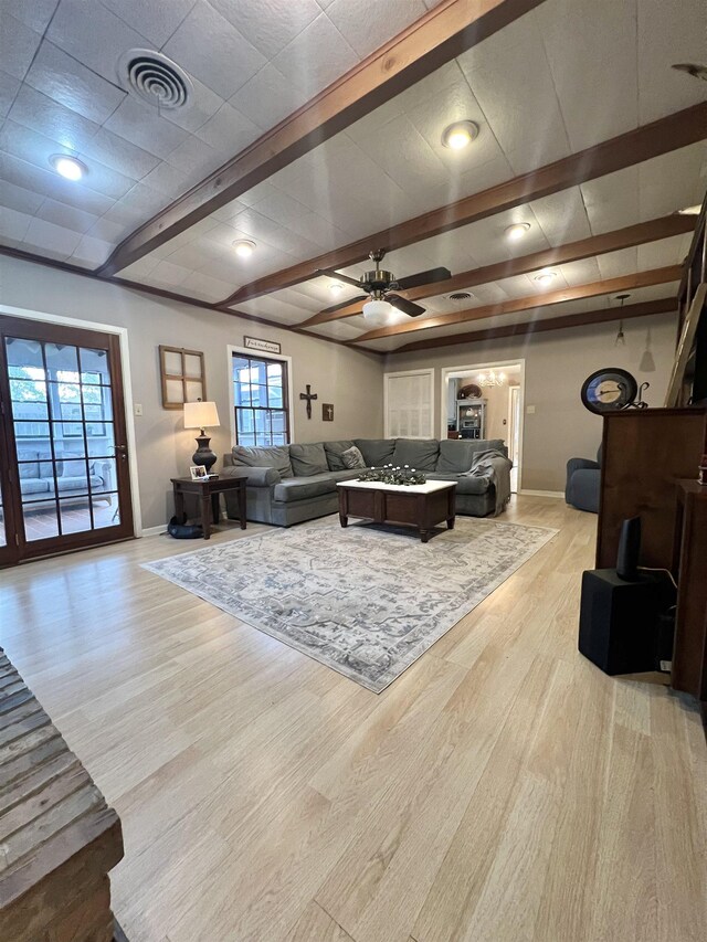 living room with ceiling fan, light wood-type flooring, and a healthy amount of sunlight