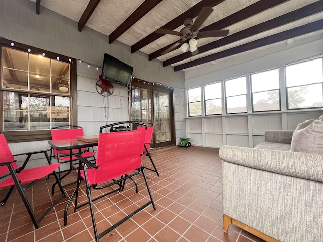 sunroom with ceiling fan, beamed ceiling, and plenty of natural light