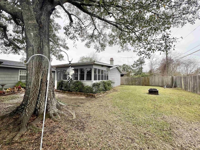 view of yard featuring a sunroom and a fire pit