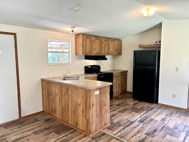 kitchen featuring extractor fan, dark wood-type flooring, vaulted ceiling, black appliances, and sink