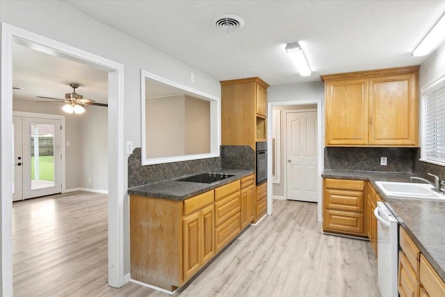 kitchen with sink, french doors, light hardwood / wood-style floors, decorative backsplash, and black appliances