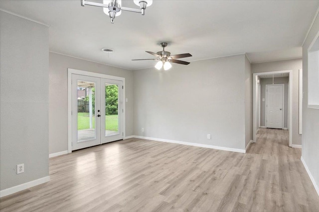 spare room with light wood-type flooring, french doors, and ceiling fan with notable chandelier