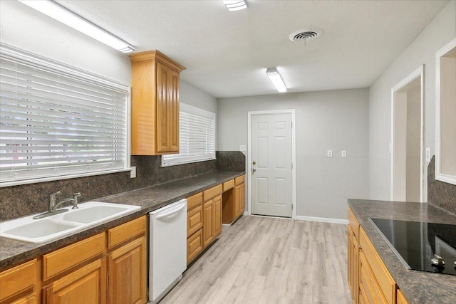 kitchen with dishwasher, black electric stovetop, sink, light hardwood / wood-style flooring, and tasteful backsplash