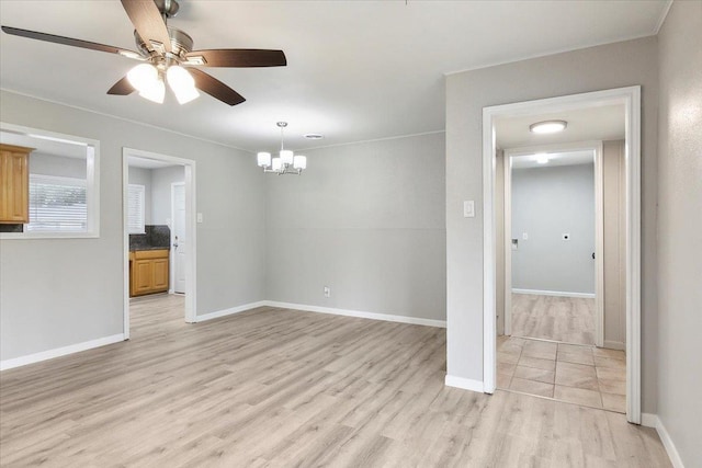 spare room with ceiling fan with notable chandelier and light hardwood / wood-style flooring