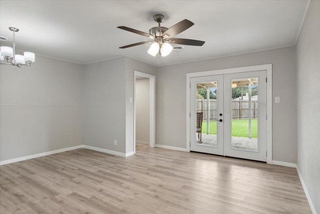 interior space featuring ceiling fan with notable chandelier, light hardwood / wood-style flooring, and french doors