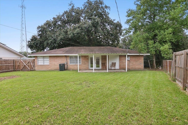 rear view of property with french doors, a patio, cooling unit, and a lawn