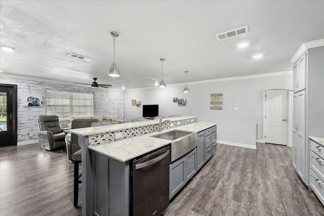 kitchen featuring visible vents, open floor plan, dishwasher, a textured ceiling, and a sink