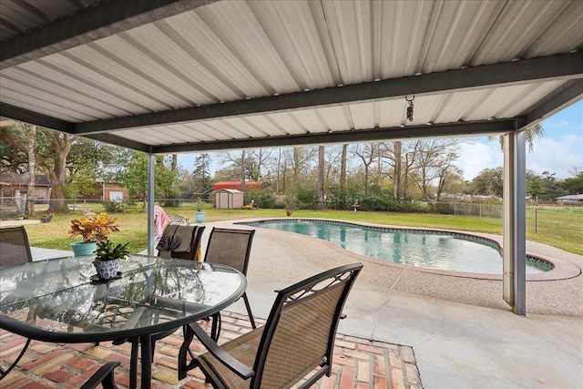 pool with a patio, an outbuilding, a fenced backyard, a storage unit, and a lawn