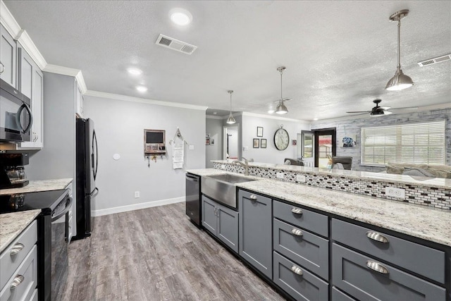 kitchen with black appliances, gray cabinetry, visible vents, and a sink