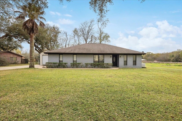 view of front facade featuring a front yard, an attached garage, brick siding, and driveway