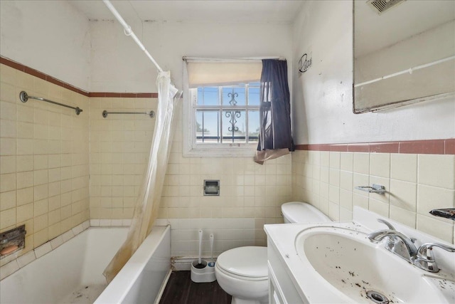 bathroom featuring a sink, shower / bath combo, toilet, tile walls, and visible vents