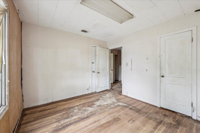 spare room featuring wood-type flooring and visible vents