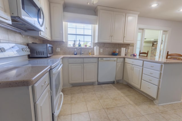 6470 Wilder Dr, Beaumont, TX 77706 - kitchen with white appliances, a sink, a peninsula, backsplash, and recessed lighting