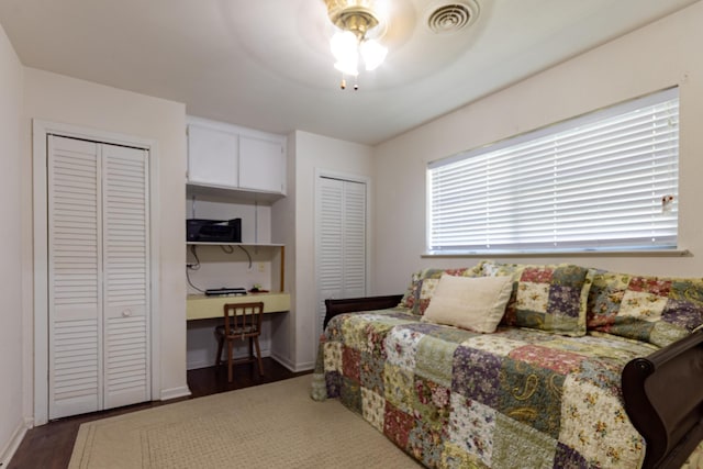 6470 Wilder Dr, Beaumont, TX 77706 - bedroom featuring two closets, wood finished floors, baseboards, and ceiling fan