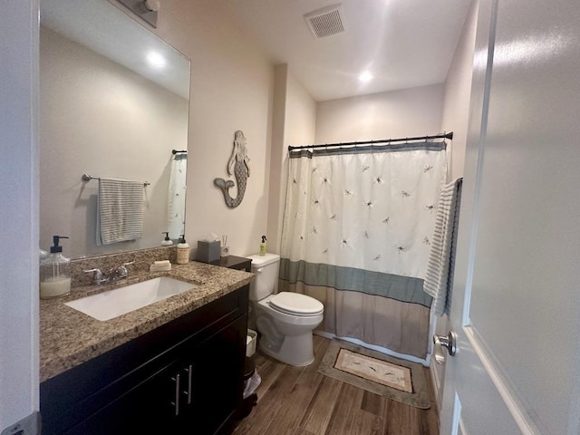 full bathroom with hardwood / wood-style flooring, vanity, toilet, and shower / bath combo with shower curtain