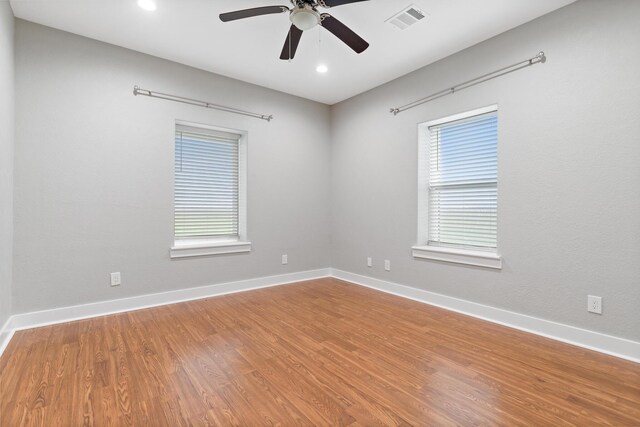 2050 Aggie Dr, Beaumont, TX 77713 - unfurnished room with a ceiling fan, wood finished floors, baseboards, visible vents, and a healthy amount of sunlight