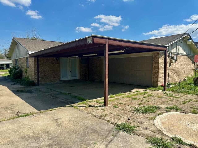 4220 Flamingo Ln, Beaumont, TX 77705 - view of property exterior with brick siding, a carport, french doors, and concrete driveway