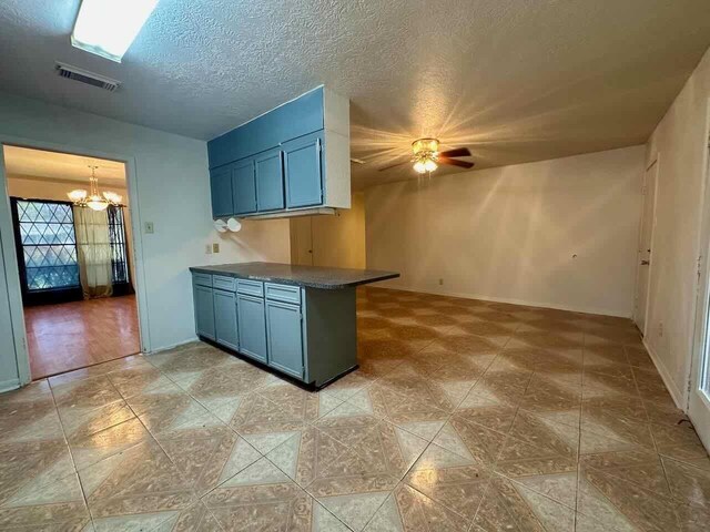 4220 Flamingo Ln, Beaumont, TX 77705 - kitchen featuring a chandelier, dark countertops, ceiling fan, blue cabinetry, and a textured ceiling