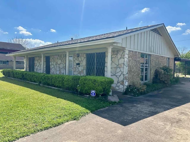4220 Flamingo Ln, Beaumont, TX 77705 - view of home's exterior with board and batten siding, a yard, stone siding, and driveway