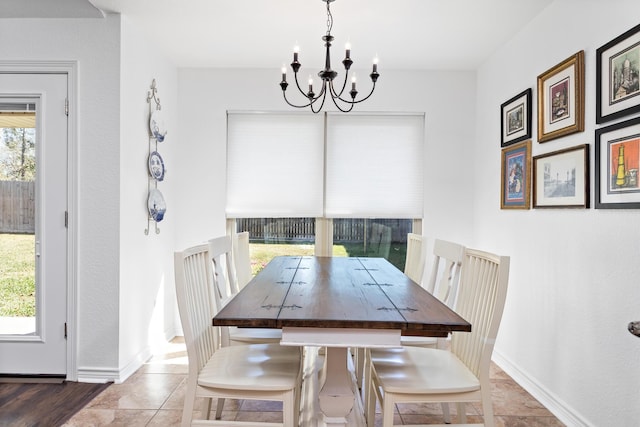 tiled dining room featuring an inviting chandelier