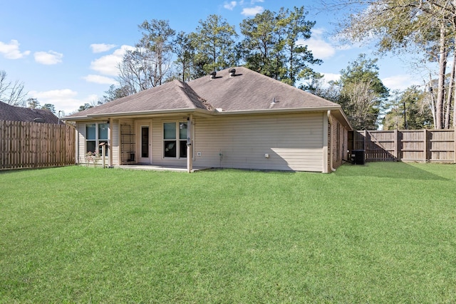 rear view of property featuring a yard and central air condition unit