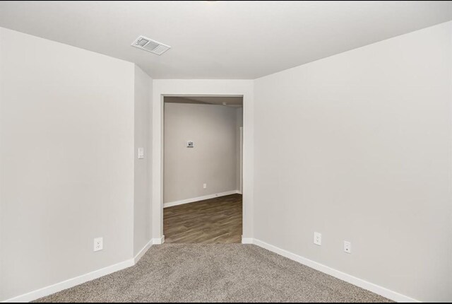 carpeted empty room with baseboards and visible vents