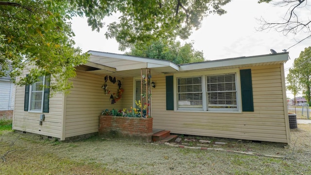 view of front of house with a front yard and central AC