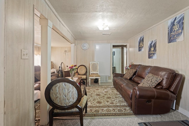 2850 S Major Dr, Beaumont, TX 77707 - carpeted living room featuring ornamental molding, a textured ceiling, and wood walls