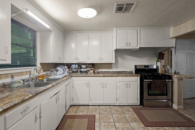 2850 S Major Dr, Beaumont, TX 77707 - kitchen featuring gas stove, white cabinets, a textured ceiling, and light tile patterned floors