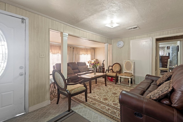 2850 S Major Dr, Beaumont, TX 77707 - carpeted living room with decorative columns, ornamental molding, a textured ceiling, and wooden walls