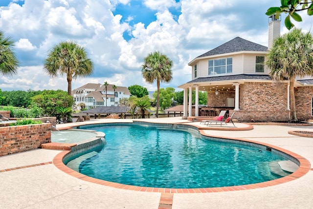 view of swimming pool with a patio area, pool water feature, and exterior bar