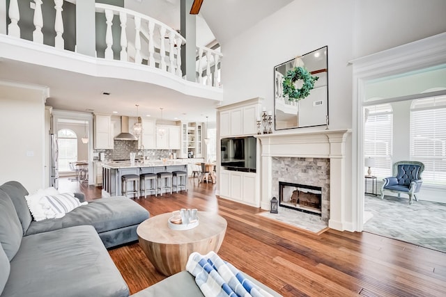 living room with a fireplace, a high ceiling, and hardwood / wood-style flooring