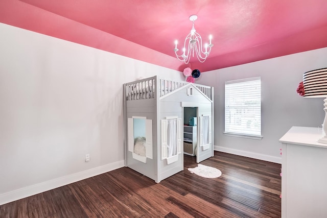 unfurnished bedroom with dark wood-type flooring and a chandelier