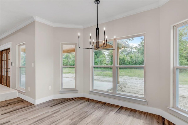 unfurnished dining area featuring light hardwood / wood-style flooring, an inviting chandelier, and ornamental molding