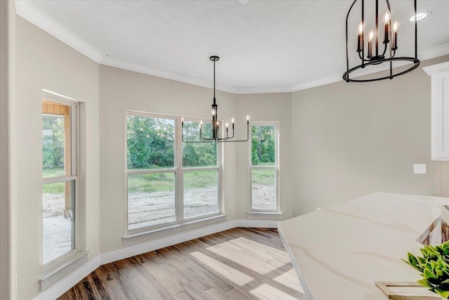 dining space with light hardwood / wood-style floors, crown molding, and a chandelier