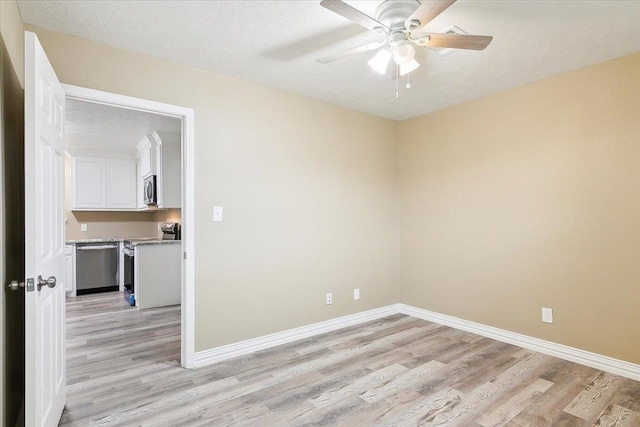 unfurnished room with ceiling fan, light hardwood / wood-style floors, and a textured ceiling