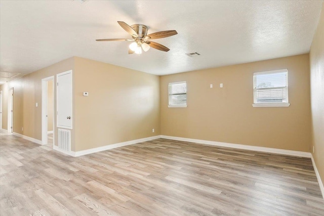 unfurnished room with a textured ceiling, light hardwood / wood-style floors, and ceiling fan