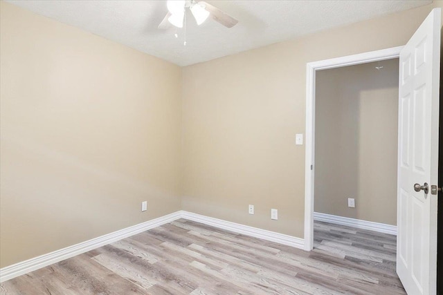 empty room with a textured ceiling, light wood-type flooring, and ceiling fan