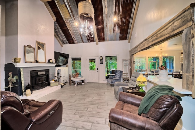 living room with a chandelier, high vaulted ceiling, and light hardwood / wood-style flooring