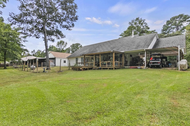 back of house with a carport, a sunroom, and a lawn