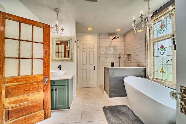 bathroom featuring an inviting chandelier, tile walls, a textured ceiling, vanity, and tile patterned flooring