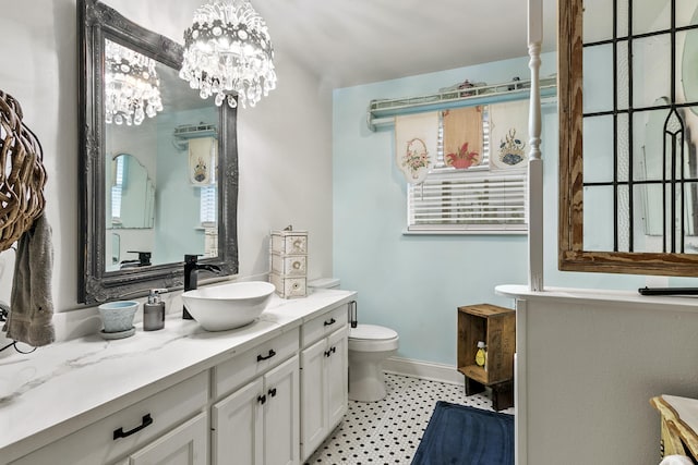 bathroom with vanity, toilet, and a chandelier