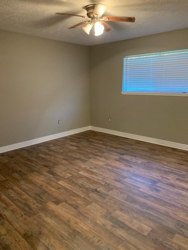 empty room featuring a textured ceiling, baseboards, dark wood-style flooring, and ceiling fan